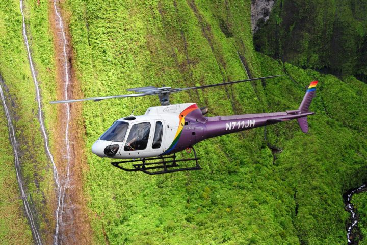 a helicopter with lush mountains in the background