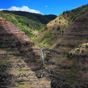 a narrow valley with multiple tiers of waterfalls