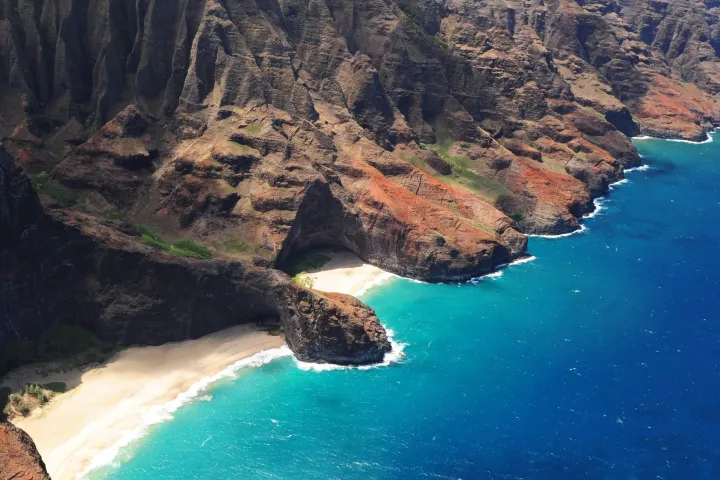 a body of water with Nā Pali Coast in the background