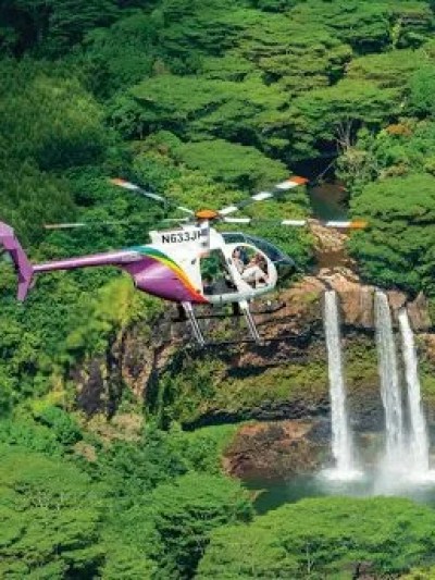 doors-off helicopter over a waterfall