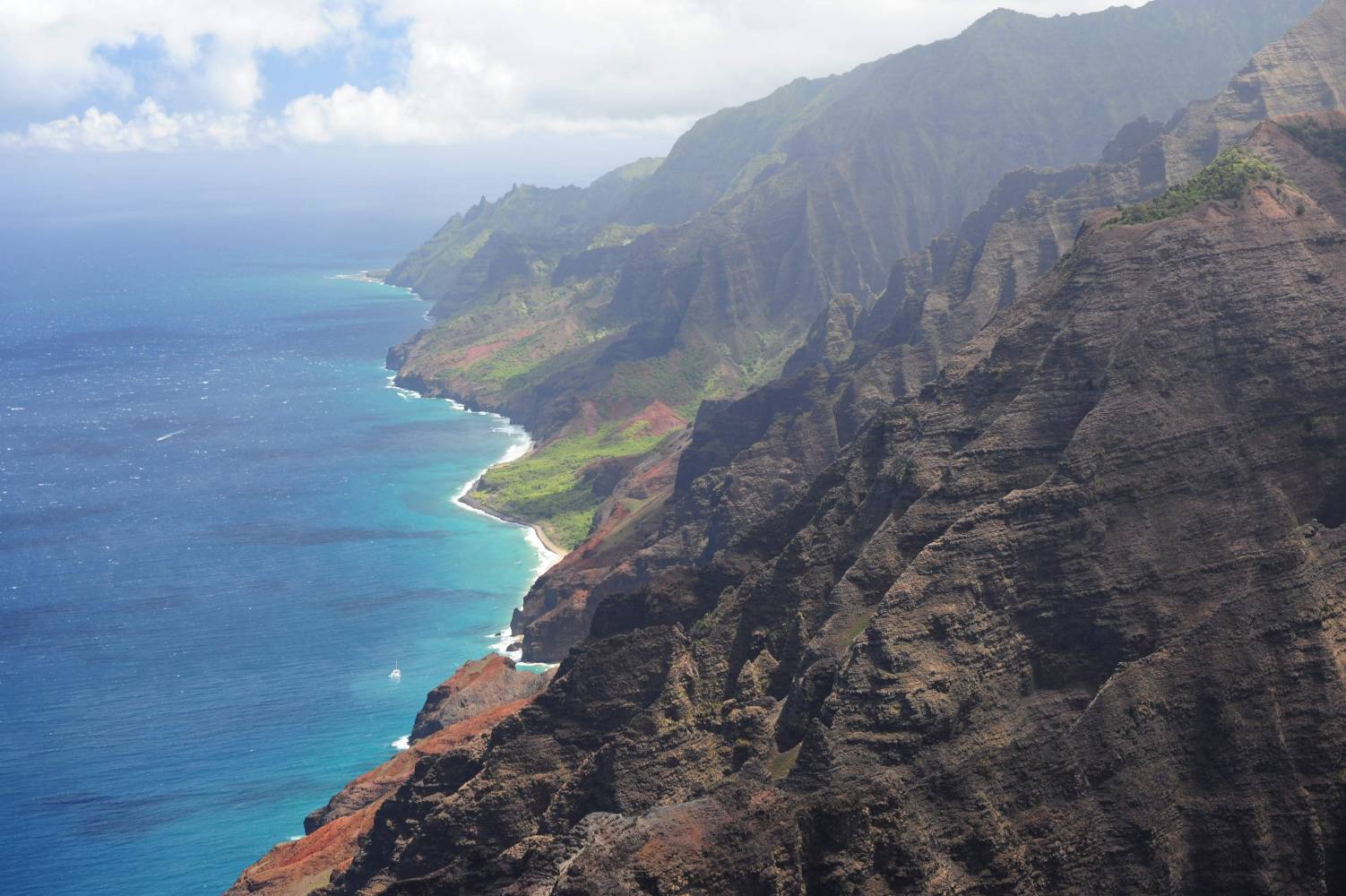 a view of a large body of water with Nā Pali Coast State Park in the background