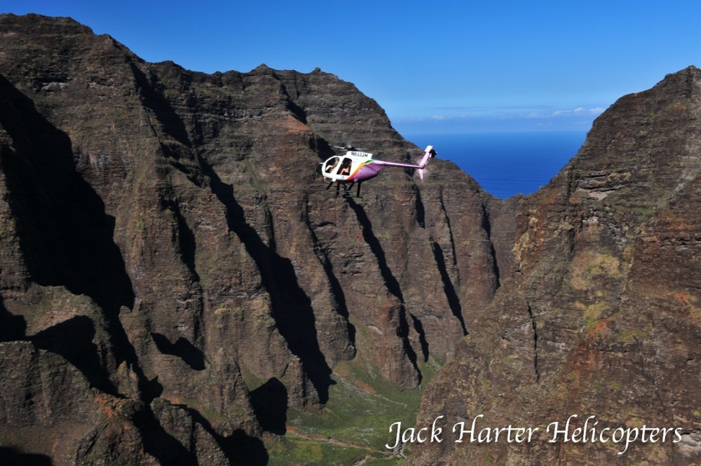 a man flying through the air on a rocky hill